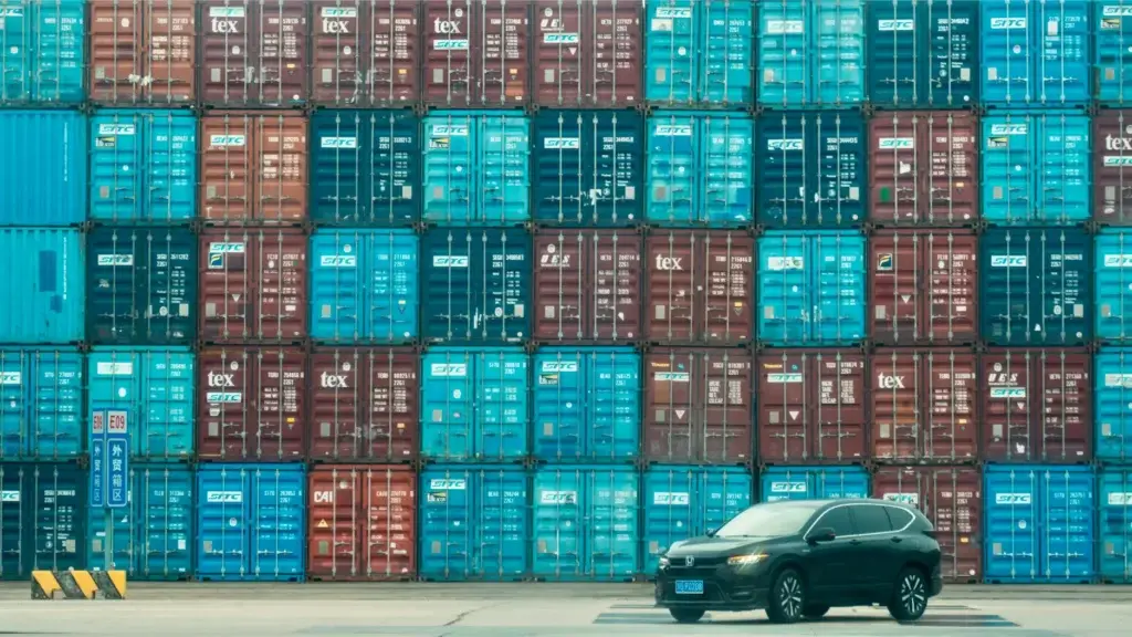 Auto enviado con flete maritimo frente a contenedores en el puerto